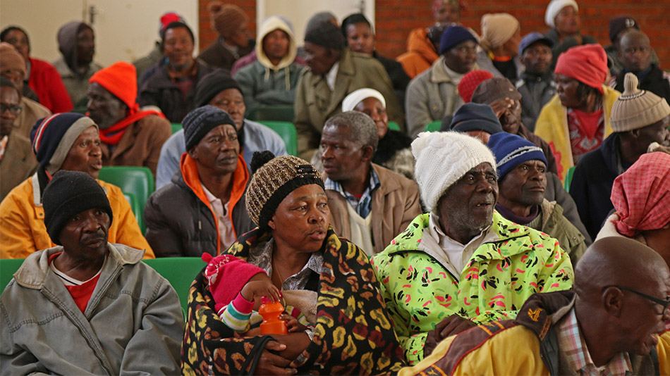 WAITING FOR JUSTICE: The families of affected miners listen carefully to the latest update on the class action suit from Mpai Nompi. Among them was Alfred Sitoe, the oldest member of the class action. PHOTO CREDIT: JOHANNA CHISHOLM