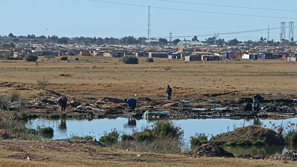 PANNING ILLEGALLY: Outside the mines, job opportunities are scarce in Virginia. Many young unemployed men engage in the illegal mining trade and pan for gold in local water sources. PHOTO CREDIT: JOHANNA CHISHOLM